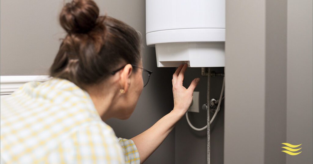 lady technician inspecting hot water tank 